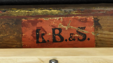 Detail der Rückseite des Gemäldes von Dora Hitz, Klebezettel mit aufgedruckten Initialen „L.B. & S.“ Detail der Rückseite des Gemäldes von Dora Hitz, Klebezettel mit aufgedruckten Initialen „L.B. & S.“