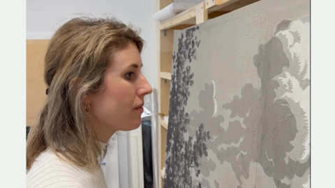 Tapetenmuseum Frau schaut auf Tapete.